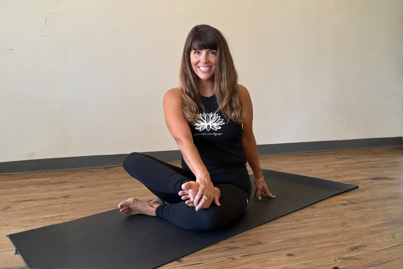 A seated twist on the mat in the studio, smiling