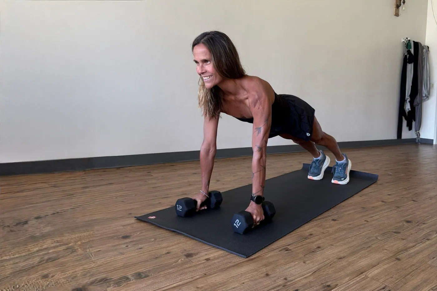 A plank with dumbbells on the mat
