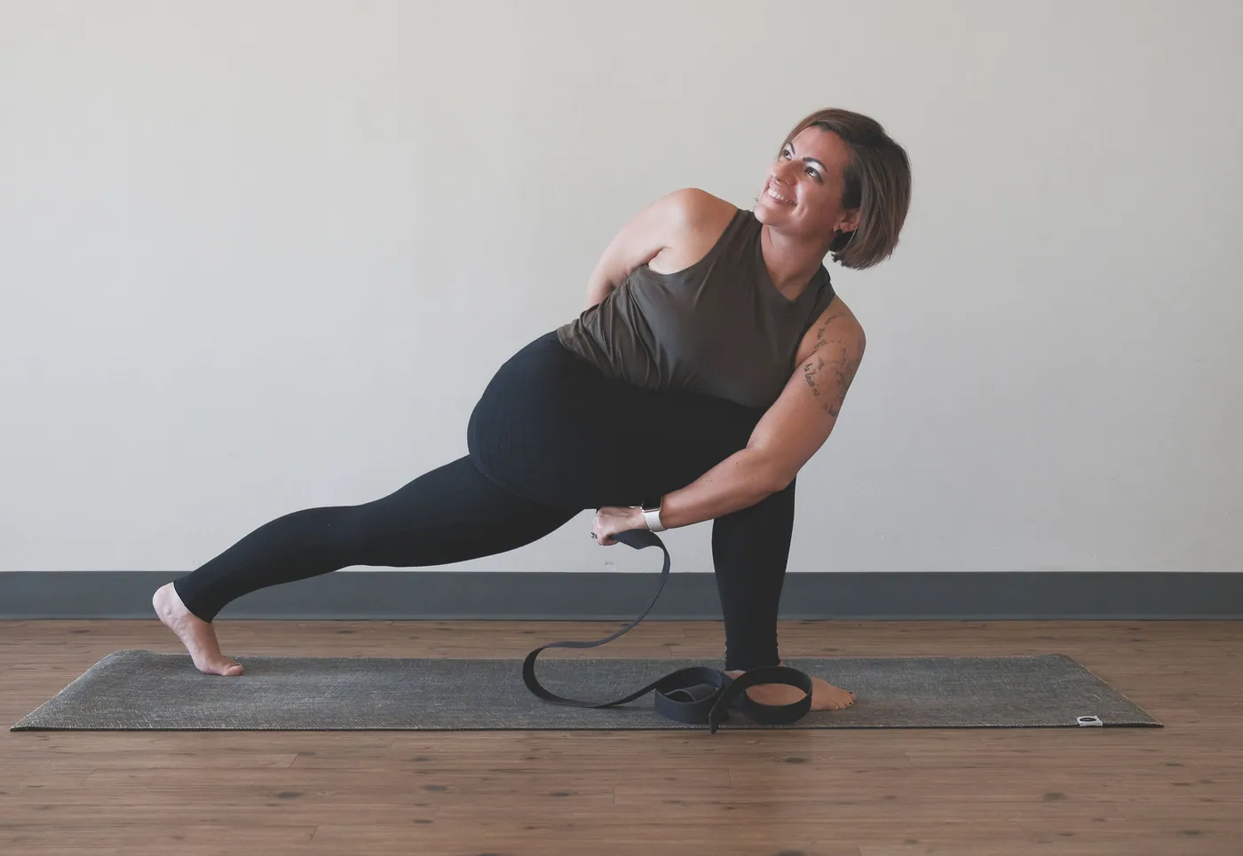 A revolved lunge with a strap on the mat